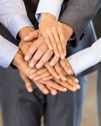 close-up-business-people-stacking-hands-meeting-office